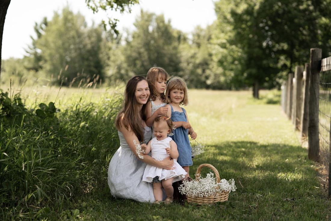 Sarah with her three little girls in a summer field